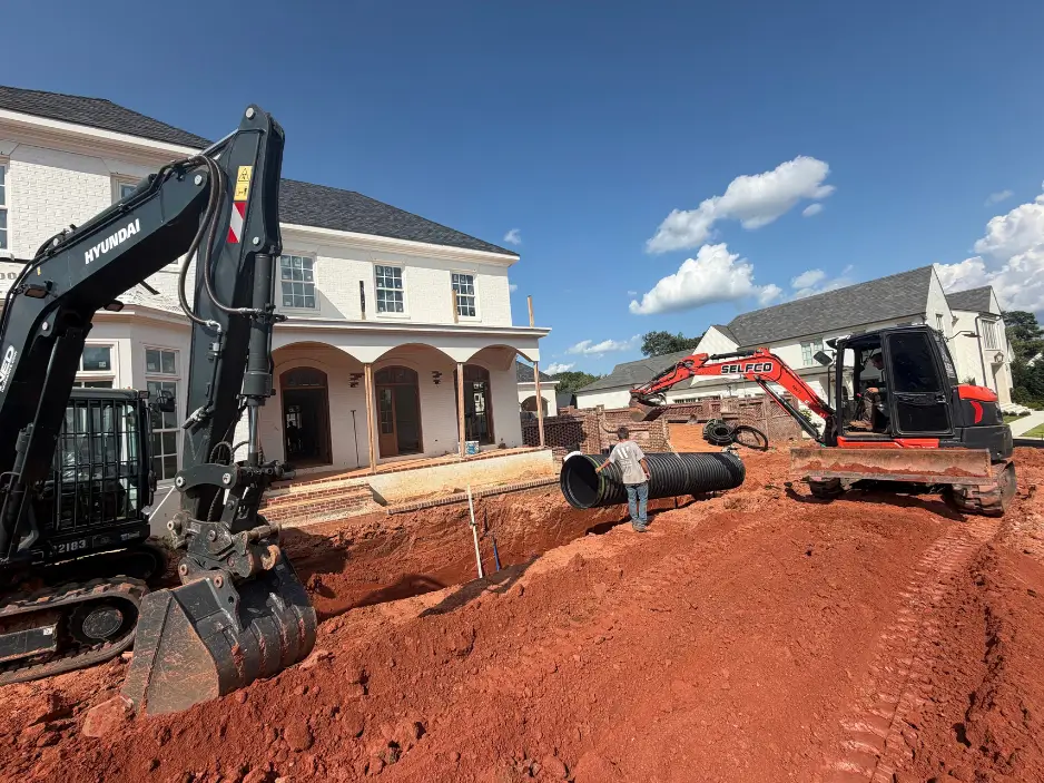 Excavators installing underground stormwater detention pipe during residential construction